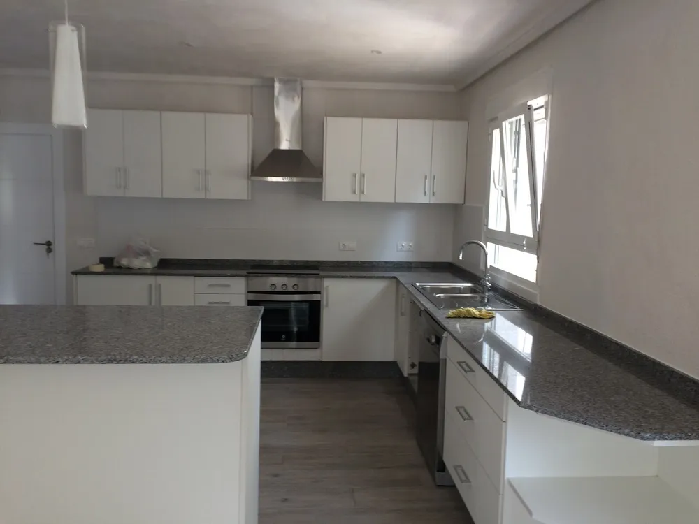 Kitchen renovated by URPE Spain in white with a granite worktop